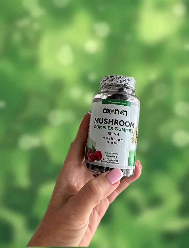 Hand holding a bottle of AXONON Mushroom Complex Gummies